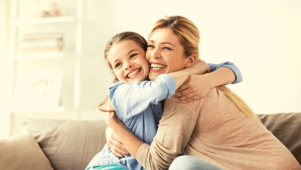 Mother smiling and hugging her daughter after dealing with dental anxiety in Northampton