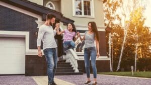 Man and woman swinging their daughter by the hands in their driveway after getting dental fillings