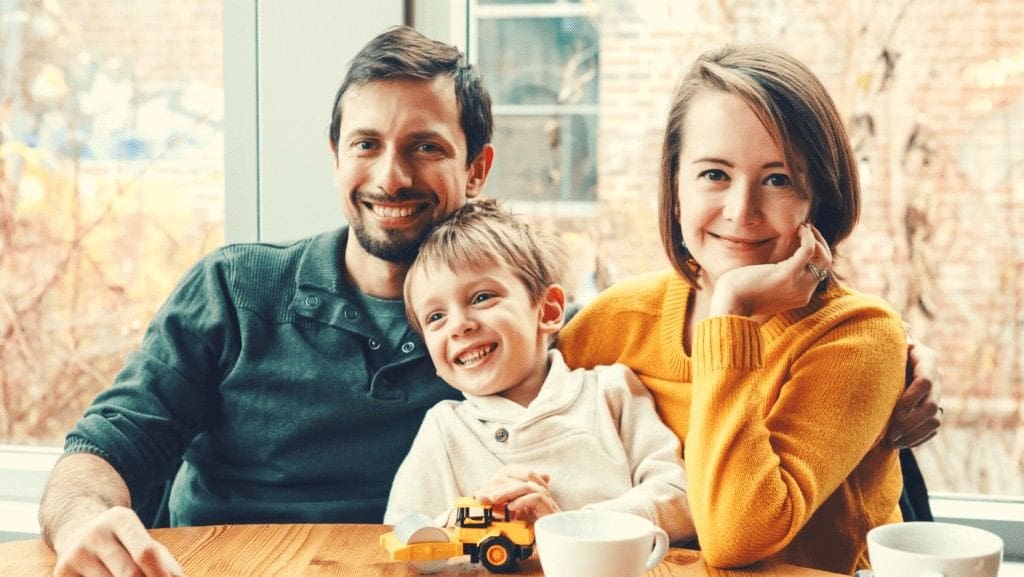 Man and woman sitting at kitchen table with their son after scaling and root planing in Northampton