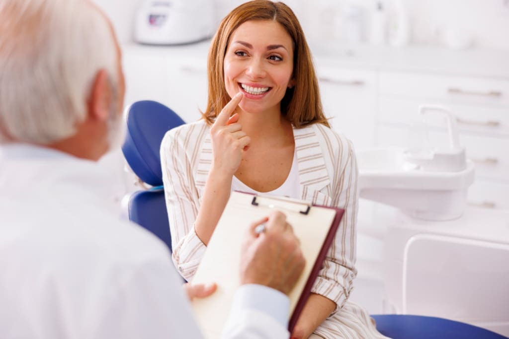 Dentist taking medical records from patient