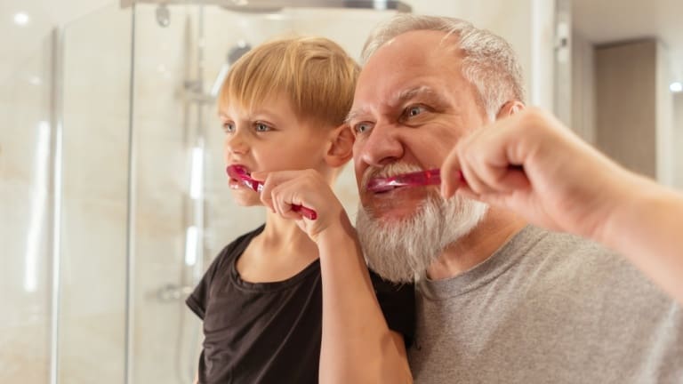 father and son brushing teeth