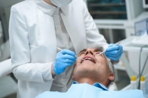 Older man getting a dental exam before receiving dentures in Northampton