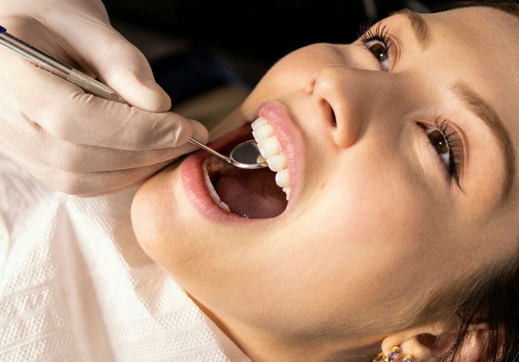 Young woman with straight teeth receiving a dental exam