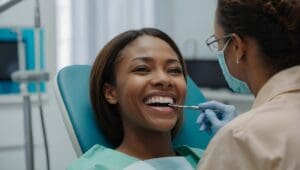 Woman smiling while having her teeth examined by her dentist