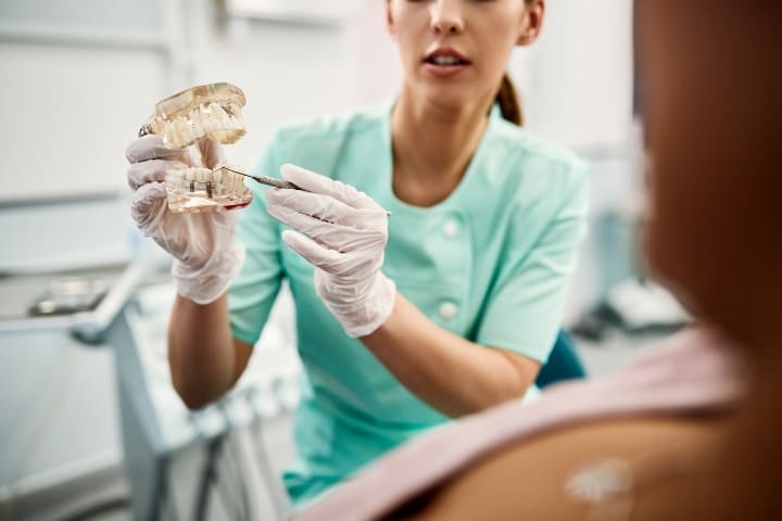 Woman dentist holding a tooth, illustrating dental health concepts