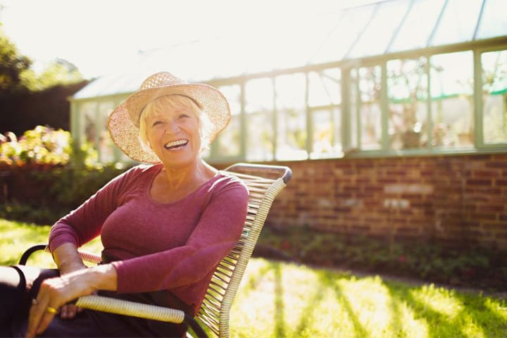Older woman smiling and showing off new dentures