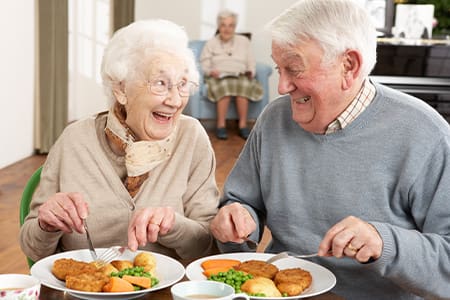 Older couple eating with dentures.