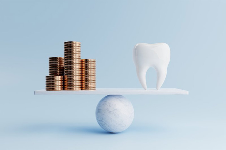 Tooth weighed against stacks of coins.