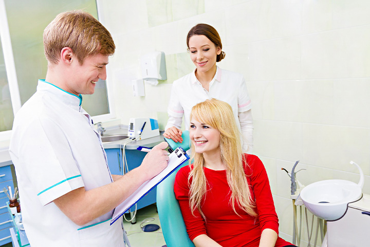 Dentist discussing dental insurance with a female patient.