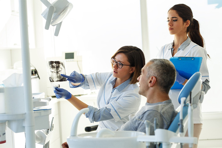 Dentist explaining factors associated with tooth extraction.