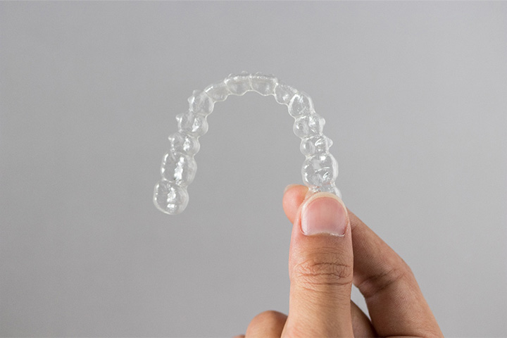 Patient holding clear aligner.